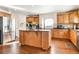Spacious kitchen featuring a large island, stainless steel appliances, and beautiful hardwood floors at 11821 Joplin Ct, Commerce City, CO 80022