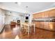 Eat-in kitchen with light wood cabinets, an island, and views into the living room at 11821 Joplin Ct, Commerce City, CO 80022