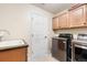 Laundry room with washer, dryer, cabinets, and a utility sink at 11821 Joplin Ct, Commerce City, CO 80022