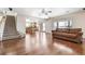 Spacious living room with hardwood floors, access to stairs and kitchen, and large window at 11821 Joplin Ct, Commerce City, CO 80022