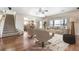 Bright living room featuring hardwood floors, neutral decor, and a seamless flow into the adjacent kitchen area at 11821 Joplin Ct, Commerce City, CO 80022