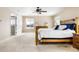 Bright main bedroom with a ceiling fan, a large window, and neutral toned walls and carpet at 11821 Joplin Ct, Commerce City, CO 80022