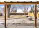 Inviting covered patio with stone flooring, a fire pit, and views of the backyard at 5141 S Grant St, Littleton, CO 80121