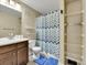 Neutral bathroom with patterned shower curtain and open shelving next to the shower at 1044 Rockhurst Dr # 202, Highlands Ranch, CO 80129