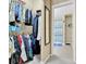 Walk-in closet leading to a bathroom with tiled floors and open shelving at 1044 Rockhurst Dr # 202, Highlands Ranch, CO 80129