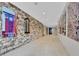 Long hallway featuring stone accent wall and modern art at 1044 Rockhurst Dr # 202, Highlands Ranch, CO 80129