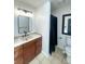 Bathroom showcasing a vanity with wood cabinets, black hardware, modern lighting, and a separate toilet and shower area at 4753 S Gar Way, Littleton, CO 80123