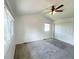 Bright bedroom featuring a ceiling fan, large windows, neutral carpeting, and a closet with white sliding doors at 4753 S Gar Way, Littleton, CO 80123