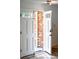 Bright entryway with a white front door, brick accent wall, and tile flooring at 4753 S Gar Way, Littleton, CO 80123