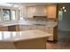 Modern kitchen with white cabinetry, island, and tile backsplash at 4753 S Gar Way, Littleton, CO 80123