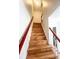 Staircase featuring hardwood steps, white risers, and wooden railings, leading to the upper level of the home at 4753 S Gar Way, Littleton, CO 80123