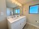 Bathroom with dual sinks, a large mirror, and modern lighting at 6556 Wolff St, Arvada, CO 80003