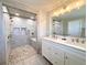 Bathroom featuring walk-in shower with rock floor, dual sinks, and modern fixtures at 6556 Wolff St, Arvada, CO 80003