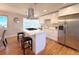 Modern kitchen with an island, quartz countertops, stainless steel appliances, and hardwood floors at 6556 Wolff St, Arvada, CO 80003