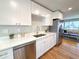 Clean kitchen featuring quartz countertops, stainless steel appliances, and views to the living room at 6556 Wolff St, Arvada, CO 80003