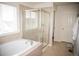 Bright bathroom with a soaking tub, glass shower enclosure, and neutral tile at 7603 Sabino Ln, Castle Rock, CO 80108