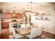 Open dining area with updated light fixture and eat in kitchen at 7603 Sabino Ln, Castle Rock, CO 80108