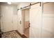 Hallway with dark hardwood floors and sliding barn door to a carpeted room at 7603 Sabino Ln, Castle Rock, CO 80108