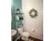 Charming powder room with shiplap accent wall, decorative wreath, and floating shelves at 7603 Sabino Ln, Castle Rock, CO 80108