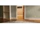 Neutral hallway showcasing hardwood floors and open doorway to additional room at 2034 S Lincoln St, Denver, CO 80210