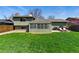 This home features a spacious backyard, patio area, well-maintained lawn, and charming sunroom at 4581 S Garrison St, Littleton, CO 80123
