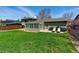 Spacious backyard featuring a lush lawn, patio area, grilling equipment, and comfortable lounge chairs at 4581 S Garrison St, Littleton, CO 80123