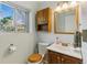 Cozy bathroom with a wood vanity cabinet and large window for natural light at 4581 S Garrison St, Littleton, CO 80123