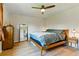 Bright bedroom featuring hardwood floors, a ceiling fan, and a large mirror that enhances the spacious feel at 4581 S Garrison St, Littleton, CO 80123