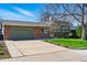 Charming home with brick and siding exterior, large driveway, and well-manicured lawn at 4581 S Garrison St, Littleton, CO 80123