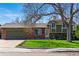 Charming home features brick and siding exterior, large driveway, and grassy front yard at 4581 S Garrison St, Littleton, CO 80123