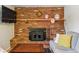 Living room fireplace with brick surround, wood mantle, and decorative elements displayed above at 4581 S Garrison St, Littleton, CO 80123