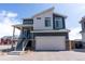 Charming two-story home with a blue and white facade, and a two-car garage with a brick driveway at 16382 E 111Th Dr, Commerce City, CO 80022