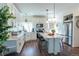 Modern kitchen featuring white cabinets, stainless steel appliances, a center island, and beautiful hardwood floors at 16382 E 111Th Dr, Commerce City, CO 80022