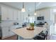 Well-lit kitchen with stainless steel appliances, white cabinets, a center island, and stylish pendant lighting at 16382 E 111Th Dr, Commerce City, CO 80022