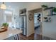 Bright kitchen with stainless steel refrigerator, white cabinets, and an adjacent doorway leading to a bedroom at 16382 E 111Th Dr, Commerce City, CO 80022