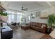 Bright living room featuring a stylish leather sofa, modern decor, and ample natural light from large windows at 16382 E 111Th Dr, Commerce City, CO 80022