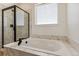 Bright bathroom features a soaking tub, a separate glass shower, and marble tile at 42982 Colonial Trl, Elizabeth, CO 80107