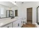 Modern bathroom with white vanity, black fixtures, large mirror, and a glass-enclosed shower at 42982 Colonial Trl, Elizabeth, CO 80107