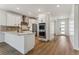 Open concept kitchen features stainless steel appliances, an island, white cabinets, and hardwood flooring at 42982 Colonial Trl, Elizabeth, CO 80107