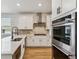 Modern kitchen features white cabinets, quartz countertops, stainless steel appliances and a herringbone backsplash at 42982 Colonial Trl, Elizabeth, CO 80107