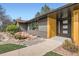 Modern home entrance boasting wood elements, sleek black accents, and stylish landscaping features at 4 Meadowlark Ln, Littleton, CO 80123