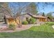 Charming single-story home featuring a well-manicured lawn, mature trees, and unique rock landscaping at 4 Meadowlark Ln, Littleton, CO 80123
