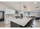 Bright, open kitchen featuring an island with bar seating, stainless steel appliances, and modern pendant lighting at 4 Meadowlark Ln, Littleton, CO 80123