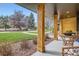 Welcoming porch showcasing natural wood columns, comfortable seating, and beautiful views of the outdoors at 4 Meadowlark Ln, Littleton, CO 80123