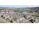 Wide aerial view of a condo community with several buildings, parking, and streets with surrounding neighborhood in background at 1574 Olympia Cir # 305, Castle Rock, CO 80104