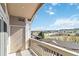 Balcony view with railing overlooking neighborhood trees and a distant hillside at 1574 Olympia Cir # 305, Castle Rock, CO 80104