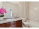 Bathroom with granite counters, wood cabinets, a shower-tub combo, and a decorative pink flower at 1574 Olympia Cir # 305, Castle Rock, CO 80104