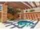 Community hot tub with wooden pergola, brick pillars, and lush landscaping at 1574 Olympia Cir # 305, Castle Rock, CO 80104
