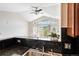 Kitchen sink and countertops overlook the spacious living room with fireplace and access to outdoor deck at 1574 Olympia Cir # 305, Castle Rock, CO 80104