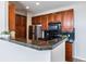 Kitchen boasts stainless steel appliances, dark countertops, and ample storage space, with views into the living room at 1574 Olympia Cir # 305, Castle Rock, CO 80104